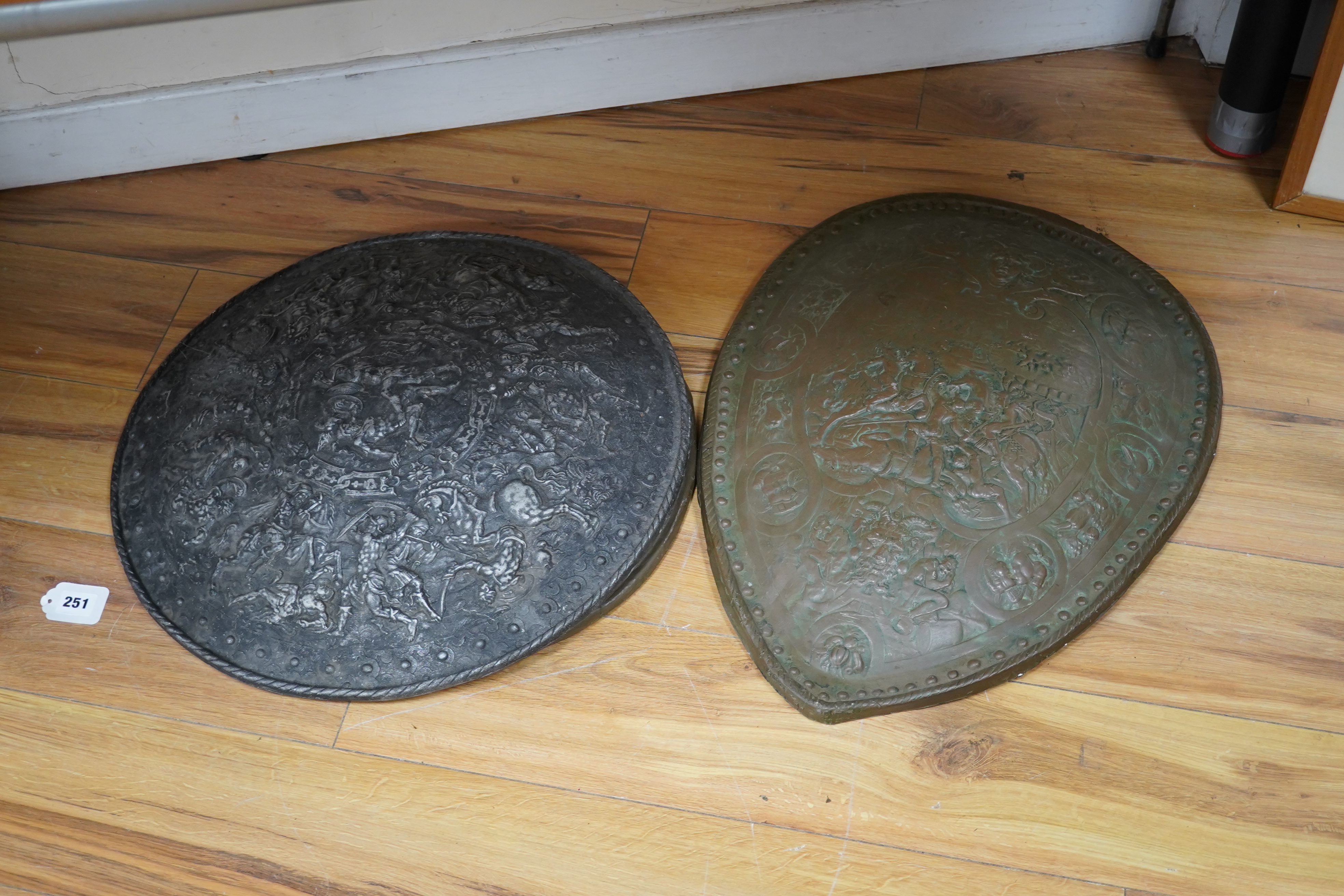 Three metal castings of decorative embossed shields, decorated with battle scenes, ancient armour, etc., diameter of largest 51.5cm. Condition - fair